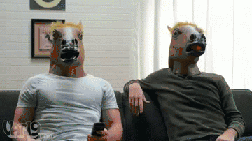 Two men in horse masks high fiving